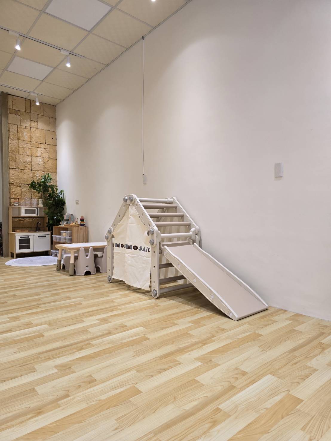 一起玩到大托育工作室內，木質地板與攀爬帳篷遊具的溫馨空間